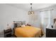 Cozy bedroom featuring a mustard yellow comforter, modern light fixture, and a decorative wall hanging at 435 E Shellie Ct, Casa Grande, AZ 85122
