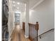 Hallway with stacked washer and dryer and wood railing on stairs at 4401 N 24Th Pl, Phoenix, AZ 85016
