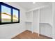 A well-lit walk-in closet offers open shelving and natural light through a dark trimmed window, enhancing organization at 4910 E Shaw Butte Dr, Scottsdale, AZ 85254