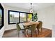 Dining area with wood table, green upholstered chairs, a modern light fixture and bright natural light at 4910 E Shaw Butte Dr, Scottsdale, AZ 85254