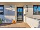Modern home entrance showcasing a sleek black door, stylish exterior lighting, and house number at 4910 E Shaw Butte Dr, Scottsdale, AZ 85254