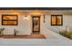 Charming front entrance with white stucco, black trim, stylish lighting, and a decorative welcome mat at 4910 E Shaw Butte Dr, Scottsdale, AZ 85254