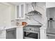 Close up on range with stainless steel hood, white cabinets and backsplash, in updated kitchen at 4910 E Shaw Butte Dr, Scottsdale, AZ 85254