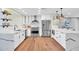 Modern kitchen featuring white cabinets, stainless steel appliances, designer countertops, and wood flooring at 4910 E Shaw Butte Dr, Scottsdale, AZ 85254