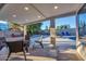 Inviting covered patio featuring travertine tile flooring and wicker furniture, perfect for outdoor entertaining at 4910 E Shaw Butte Dr, Scottsdale, AZ 85254