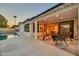 A covered patio featuring travertine tile and direct access to both the pool and the home's interior at 4910 E Shaw Butte Dr, Scottsdale, AZ 85254
