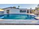 Rear view of home showcasing a pristine swimming pool, covered patio, and manicured landscaping at 4910 E Shaw Butte Dr, Scottsdale, AZ 85254