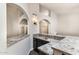 Stylish bar area featuring granite countertops, dark wood cabinetry, arched entryways, and accent lighting at 5132 E Grandview Rd, Scottsdale, AZ 85254