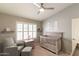 Bedroom with neutral color palette, ceiling fan, plantation shutters, crib, and armchair at 5132 E Grandview Rd, Scottsdale, AZ 85254