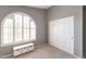 Bedroom with arched window featuring plantation shutters, neutral walls, and sliding closet doors at 5132 E Grandview Rd, Scottsdale, AZ 85254