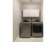 A laundry room featuring side by side, front load washer and dryer, and white cabinets at 5132 E Grandview Rd, Scottsdale, AZ 85254