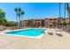 A community pool surrounded by lounge chairs and palm trees under a bright blue sky at 540 N May -- # 3117, Mesa, AZ 85201