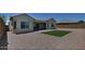 Expansive backyard with a well-manicured lawn, gravel, and a covered patio, ideal for outdoor living at 5490 W Trenton Way, Florence, AZ 85132