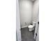 Modern half-bathroom with gray tile flooring, a standard toilet, and a built-in toilet paper holder at 5490 W Trenton Way, Florence, AZ 85132