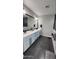 Modern bathroom with dual sinks, white cabinets, black hardware, dark tile flooring, and a large framed mirror at 5490 W Trenton Way, Florence, AZ 85132