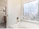 Bright bathroom featuring a large bathtub and a window with natural light at 6032 W Grovers Ave, Glendale, AZ 85308