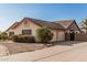 Beige single-story house featuring desert landscaping, shrubbery, and a concrete driveway at 6032 W Grovers Ave, Glendale, AZ 85308