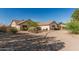 Beige single-story house featuring desert landscaping, shrubbery, and a driveway at 6032 W Grovers Ave, Glendale, AZ 85308