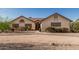 Beige single-story house featuring desert landscaping, foliage, and a walkway to the entrance at 6032 W Grovers Ave, Glendale, AZ 85308