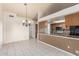 Open kitchen and dining area with tile flooring, wood cabinets, and a view of the kitchen at 6032 W Grovers Ave, Glendale, AZ 85308