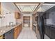 Spacious kitchen featuring granite countertops, tile floors, wood cabinets, and black appliances at 6032 W Grovers Ave, Glendale, AZ 85308