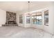 Bright living room with a stone fireplace, chandelier, and windows overlooking the backyard pool at 6032 W Grovers Ave, Glendale, AZ 85308