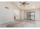 Bright living room with a fan and sliding glass doors, offering an open layout and indoor-outdoor living at 6032 W Grovers Ave, Glendale, AZ 85308