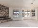 Spacious living room with a stone fireplace, large windows, and pool view at 6032 W Grovers Ave, Glendale, AZ 85308