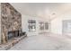 Spacious living room featuring a stone fireplace and large windows overlooking the pool area at 6032 W Grovers Ave, Glendale, AZ 85308