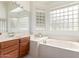 Light-filled bathroom features a large soaking tub and glass block window at 7231 W Lone Cactus Dr, Glendale, AZ 85308