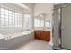 Bright bathroom features a soaking tub, glass block window, and shower stall at 7231 W Lone Cactus Dr, Glendale, AZ 85308