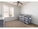 Bright Bedroom featuring a crib, ceiling fan, and plenty of natural light from the large window at 7231 W Lone Cactus Dr, Glendale, AZ 85308