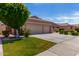 Charming single-Gathering home featuring a well-maintained lawn and a spacious driveway leading to a three-car garage at 7231 W Lone Cactus Dr, Glendale, AZ 85308