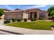 Inviting home with lush green lawn, complemented by mature landscaping and a three-car garage at 7231 W Lone Cactus Dr, Glendale, AZ 85308