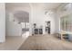 Open-concept living area with tile and carpet flooring, featuring high ceilings and seamless transitions to adjacent rooms at 7231 W Lone Cactus Dr, Glendale, AZ 85308
