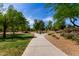Scenic view of a community park with a paved walking path and lush green landscaping at 7231 W Lone Cactus Dr, Glendale, AZ 85308