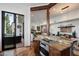 Kitchen with granite countertops, wooden beams, and an opening to the living room and outdoor area at 7272 E Gainey Ranch Rd # 29, Scottsdale, AZ 85258