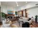Bright living room featuring a stone fireplace, ceiling fan, and access to an open floor plan at 7272 E Gainey Ranch Rd # 29, Scottsdale, AZ 85258