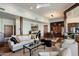 Open concept living and dining area with hardwood floors, wood pillars, and a large sofa at 7272 E Gainey Ranch Rd # 29, Scottsdale, AZ 85258
