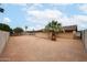 Gravel backyard featuring a border wall, palm tree and shed against a blue sky with scattered clouds at 7439 E Ed Rice Ave, Mesa, AZ 85208