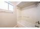 Bright bathroom featuring a bathtub with shower, window, and neutral color scheme at 7439 E Ed Rice Ave, Mesa, AZ 85208