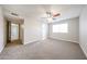 Large carpeted bedroom with ceiling fan and an ensuite bathroom providing convenience at 7439 E Ed Rice Ave, Mesa, AZ 85208