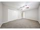 This carpeted bedroom has a ceiling fan and a large closet at 7439 E Ed Rice Ave, Mesa, AZ 85208