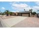 Charming single-story home with a two-car garage, desert landscaping, and a brick accent wall at 7439 E Ed Rice Ave, Mesa, AZ 85208
