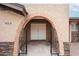 Charming front entrance with a brick archway, metal gates, and double doors at 7439 E Ed Rice Ave, Mesa, AZ 85208