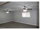 Comfortable living room with two ceiling fans, neutral carpet, and natural light from the window at 7439 E Ed Rice Ave, Mesa, AZ 85208