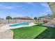Backyard featuring a sparkling swimming pool, lush green lawn, and covered patio, perfect for outdoor enjoyment at 8002 E Whitton Ave, Scottsdale, AZ 85251