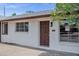 Welcoming front entrance with a solid wood door, modern light fixture, and painted brick exterior at 8002 E Whitton Ave, Scottsdale, AZ 85251