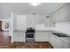 Classic kitchen with stainless steel appliances, white cabinetry, and warm terra cotta tile flooring at 8002 E Whitton Ave, Scottsdale, AZ 85251