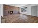 Bright living room features a brick fireplace, tiled floors, and a large window for ample natural light at 8002 E Whitton Ave, Scottsdale, AZ 85251